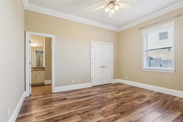 unfurnished bedroom featuring ornamental molding, dark wood-type flooring, and a closet