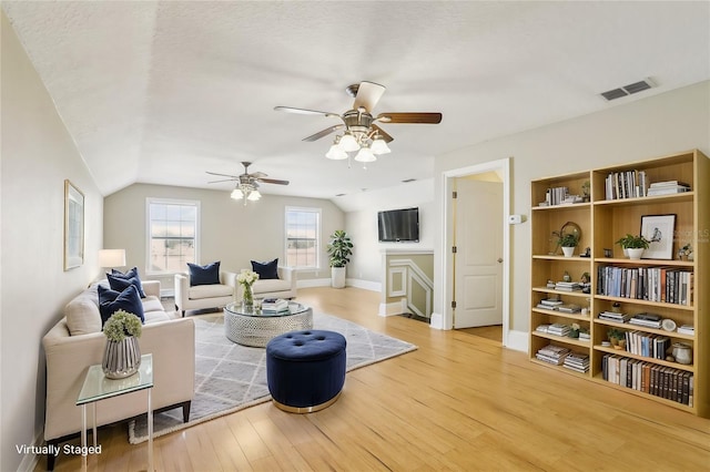 living room with hardwood / wood-style flooring, ceiling fan, and lofted ceiling