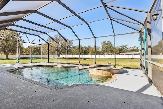 view of pool with an in ground hot tub, a yard, glass enclosure, and a patio area