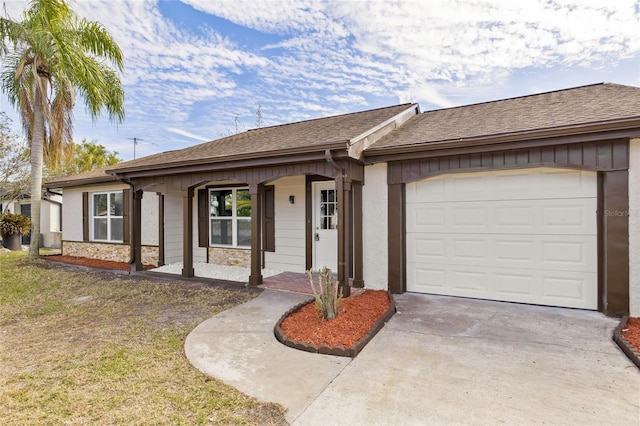 single story home with a porch, a garage, and a front yard