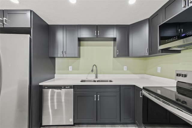 kitchen featuring stainless steel appliances, gray cabinets, sink, and a textured ceiling