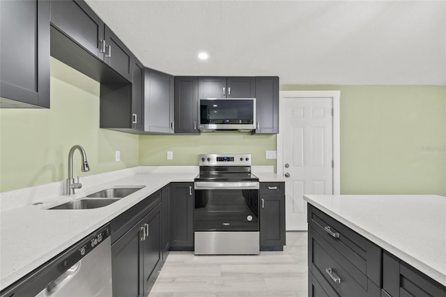 kitchen with light stone countertops, appliances with stainless steel finishes, and sink