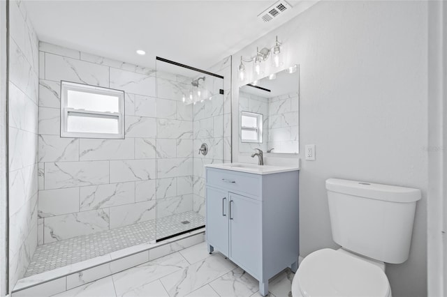 bathroom with vanity, plenty of natural light, a tile shower, and toilet