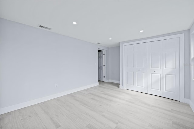 unfurnished bedroom featuring a closet and light hardwood / wood-style flooring