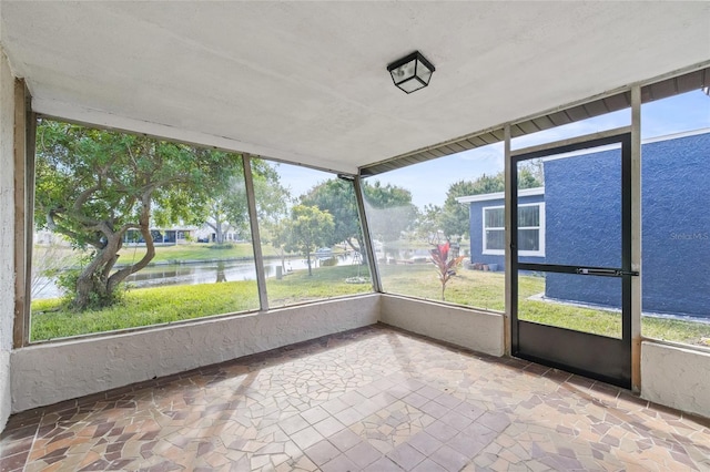 unfurnished sunroom featuring a water view