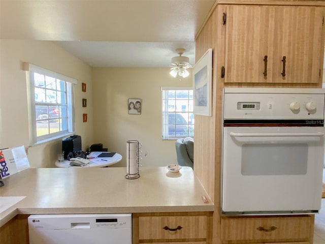 kitchen featuring white appliances, a wealth of natural light, ceiling fan, and light brown cabinets