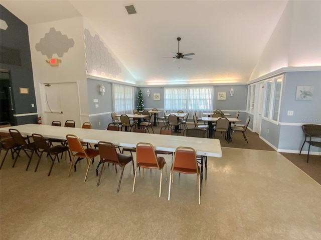 dining room with ceiling fan and high vaulted ceiling