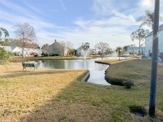 view of community with a yard and a water view