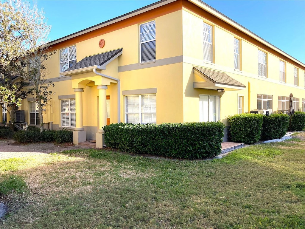 view of front of home featuring central AC and a front yard