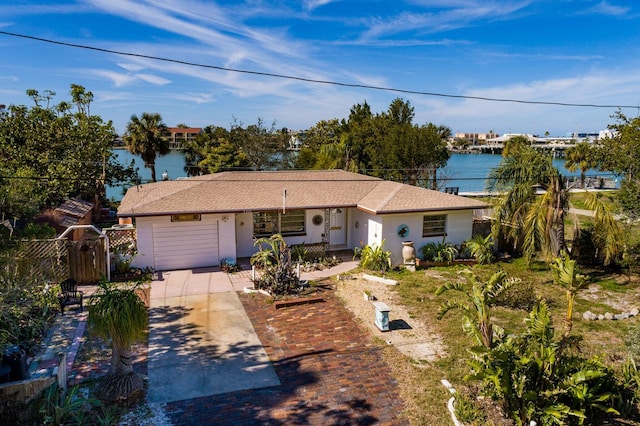 ranch-style house featuring a garage and a water view