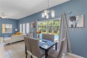 dining room featuring light tile patterned flooring and ceiling fan with notable chandelier