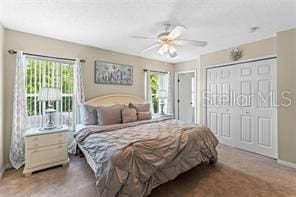 carpeted bedroom with ceiling fan and a closet