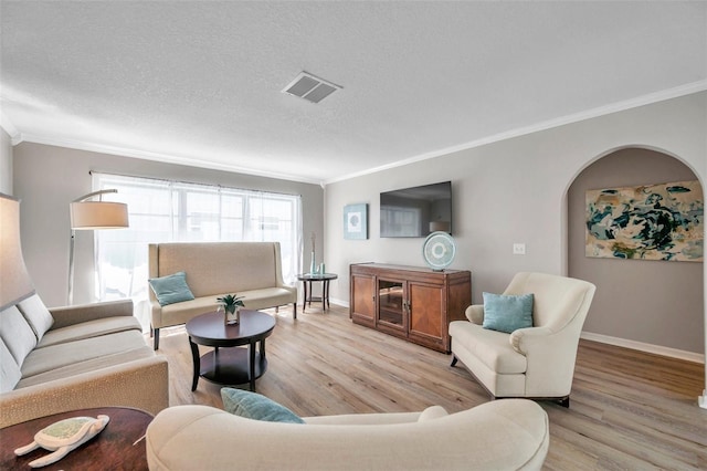 living room with a textured ceiling, crown molding, and light hardwood / wood-style flooring