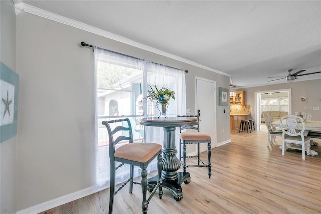 dining area with ceiling fan, ornamental molding, and light hardwood / wood-style floors