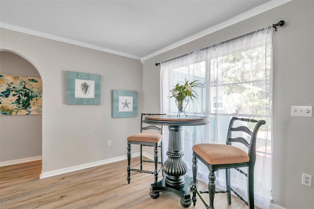 dining space with ornamental molding and light wood-type flooring