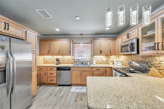 kitchen with light hardwood / wood-style flooring, sink, appliances with stainless steel finishes, crown molding, and pendant lighting