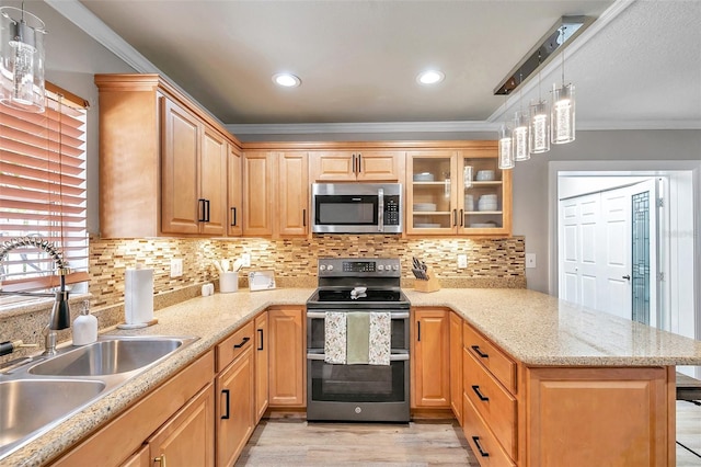 kitchen with appliances with stainless steel finishes, decorative light fixtures, crown molding, sink, and kitchen peninsula