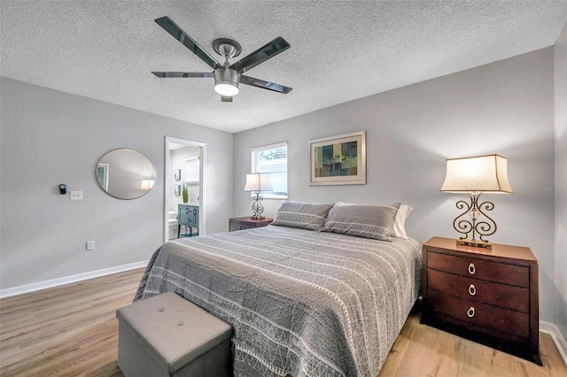 bedroom featuring ensuite bathroom, light hardwood / wood-style flooring, ceiling fan, and a textured ceiling