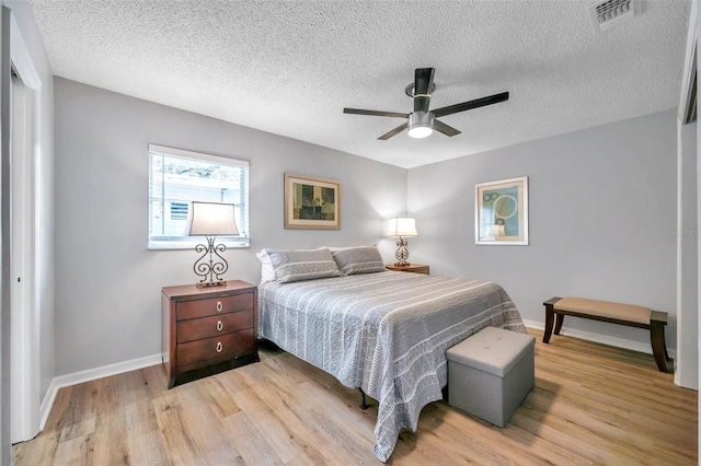 bedroom featuring a textured ceiling, ceiling fan, and light hardwood / wood-style flooring