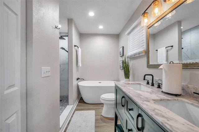 full bathroom with toilet, hardwood / wood-style flooring, plus walk in shower, and vanity