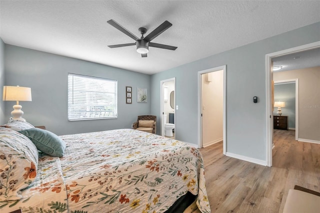 bedroom with connected bathroom, light wood-type flooring, ceiling fan, and a textured ceiling