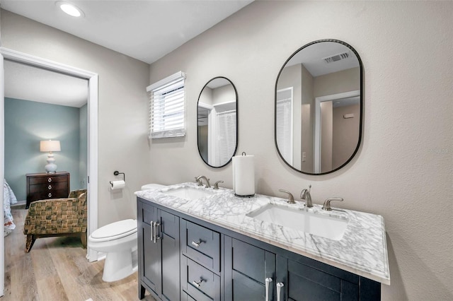 bathroom with vanity, toilet, and hardwood / wood-style floors