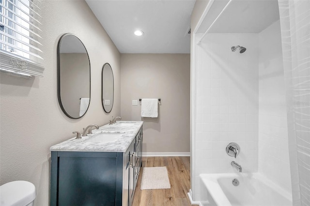 full bathroom featuring vanity, tiled shower / bath, toilet, and hardwood / wood-style floors