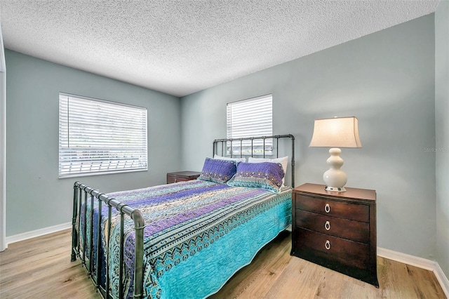 bedroom featuring light hardwood / wood-style flooring and a textured ceiling