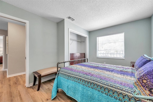 bedroom featuring light hardwood / wood-style flooring and a textured ceiling