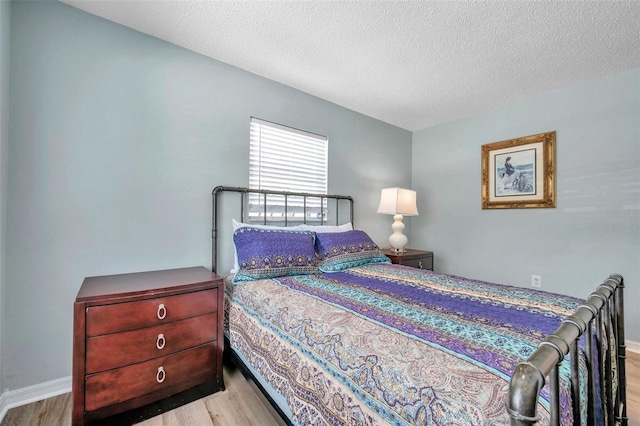 bedroom featuring light hardwood / wood-style flooring and a textured ceiling