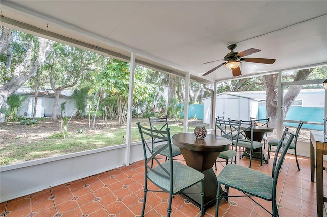 sunroom featuring a water view and ceiling fan