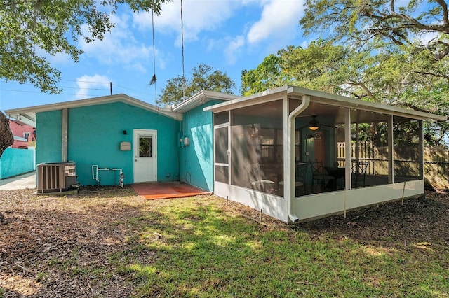 back of property with a yard, a sunroom, and central air condition unit