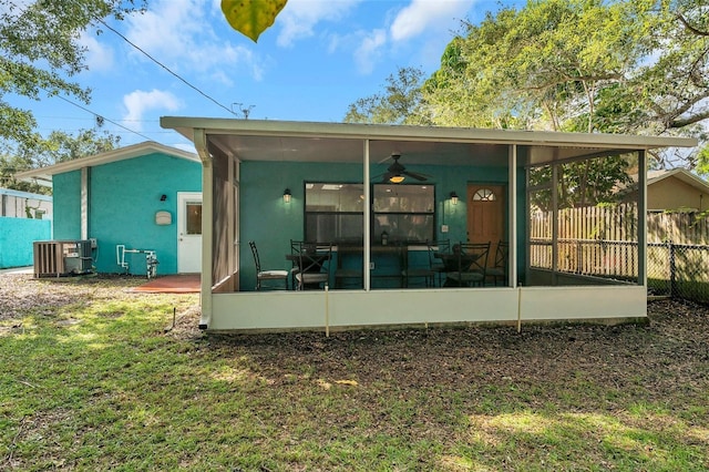 back of property with cooling unit, ceiling fan, a yard, and a sunroom