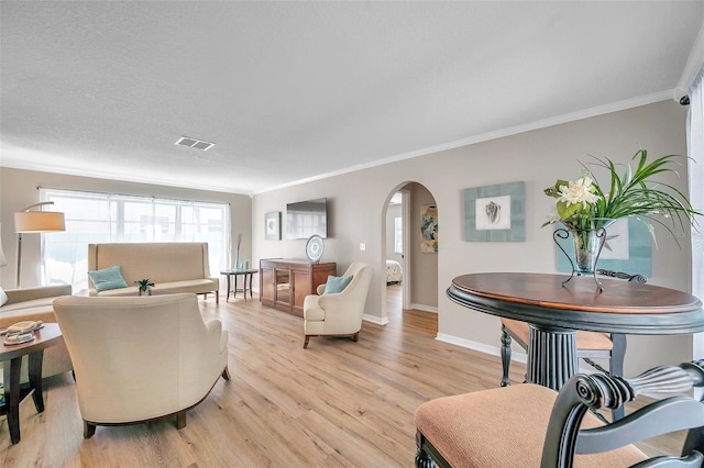 717 Carolina Ave, Tarpon Springs, FL 34689 - living area with ornamental molding, arched walkways, light wood-type flooring, and baseboards