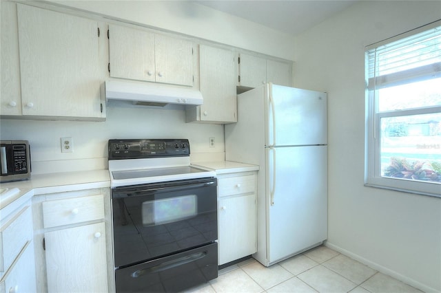 kitchen featuring black range with electric stovetop, light tile patterned floors, a wealth of natural light, and white refrigerator