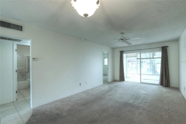 carpeted spare room with ceiling fan and a textured ceiling