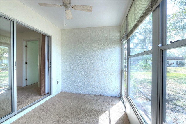 unfurnished sunroom featuring ceiling fan