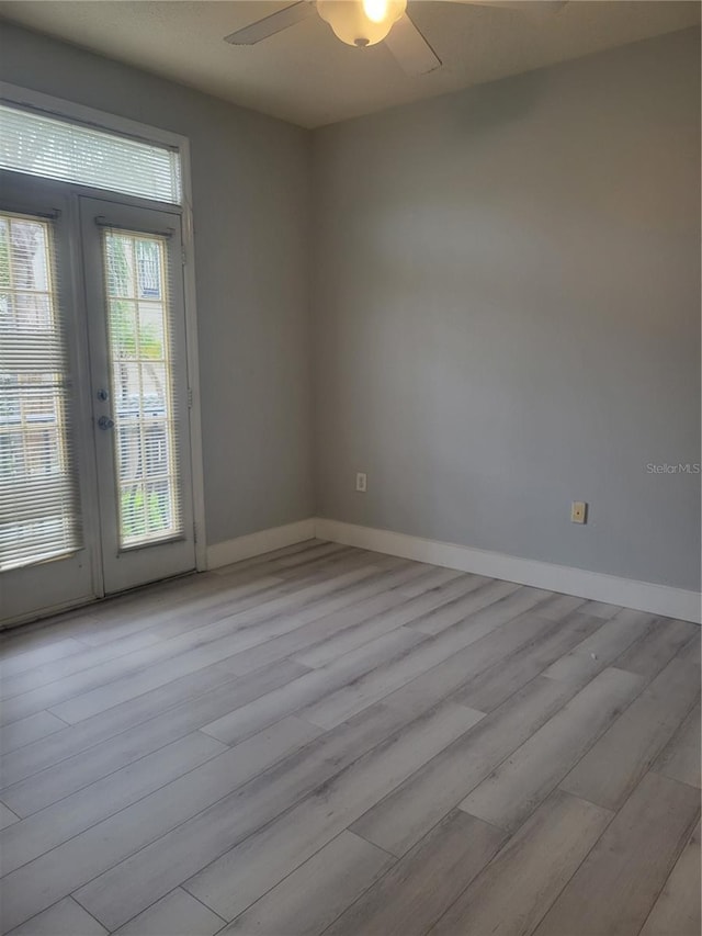 spare room with french doors, ceiling fan, and light wood-type flooring