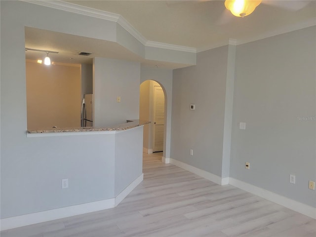 unfurnished room featuring crown molding and light hardwood / wood-style floors