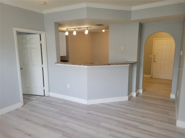 spare room featuring ornamental molding and light hardwood / wood-style floors