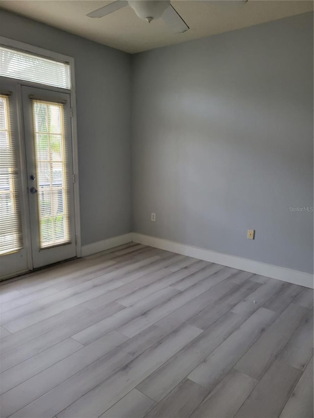 empty room with ceiling fan and light hardwood / wood-style floors