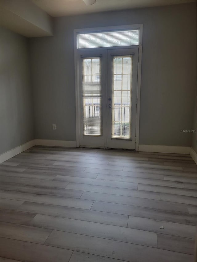 unfurnished room featuring light hardwood / wood-style floors and french doors