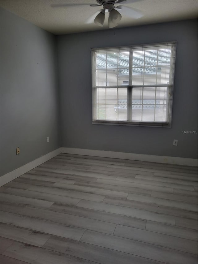 spare room featuring ceiling fan, a textured ceiling, and light wood-type flooring