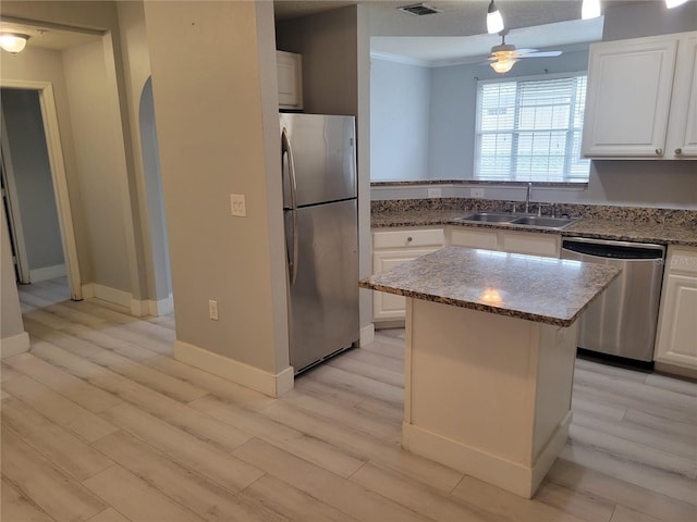 kitchen with white cabinetry, sink, a kitchen island, and appliances with stainless steel finishes