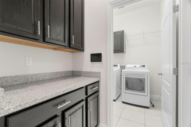 clothes washing area featuring light tile patterned flooring and washer and clothes dryer