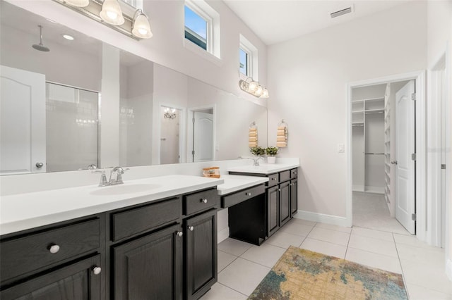 bathroom featuring vanity, a shower with shower door, and tile patterned floors