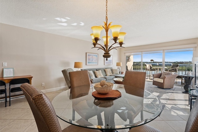 dining room featuring an inviting chandelier, a textured ceiling, and light tile patterned flooring