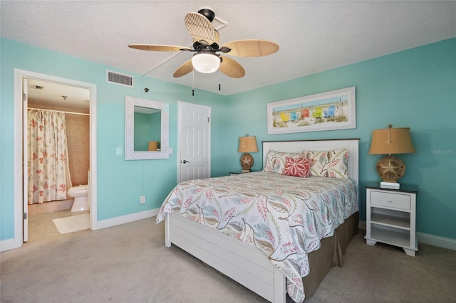 carpeted bedroom featuring ceiling fan, a textured ceiling, and ensuite bath