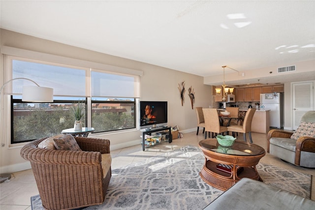 living room featuring light tile patterned flooring and an inviting chandelier