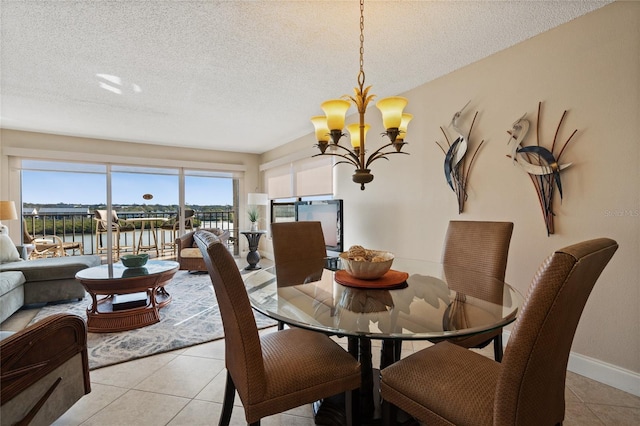 tiled dining space with a water view, a textured ceiling, and an inviting chandelier